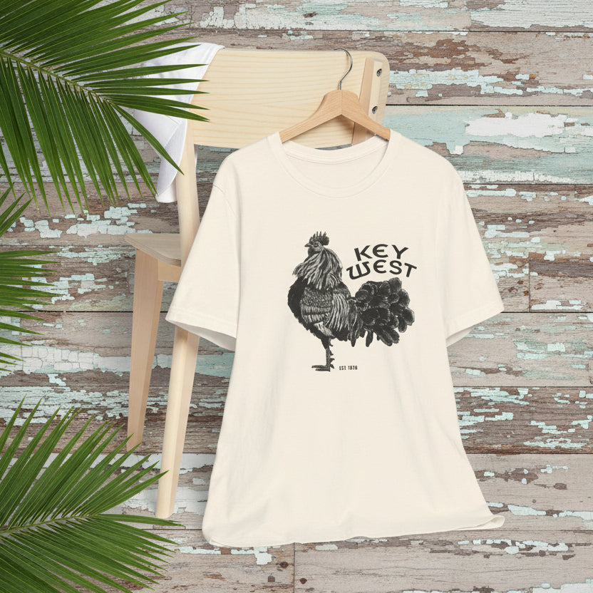 Beige t-shirt with rooster graphic and 'Key West' text on a chair against a white background