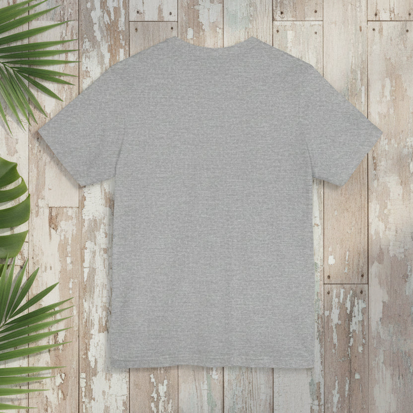 Gray t-shirt on a wooden surface with green leaves